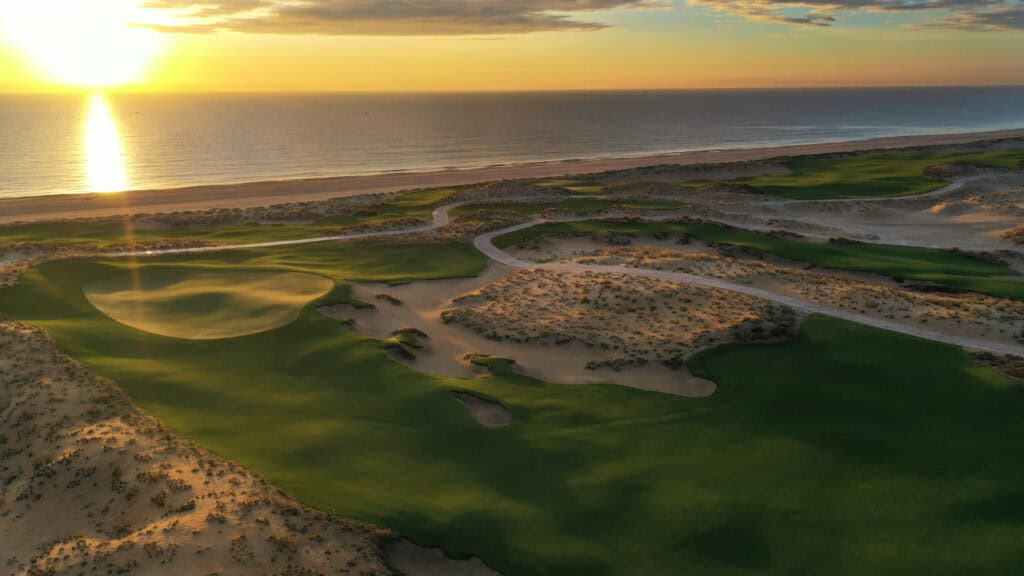 Sunrise over Hoiana Shores Golf Club near Hoi An, Vietnam, with coastal greens, sand dunes and ocean views.