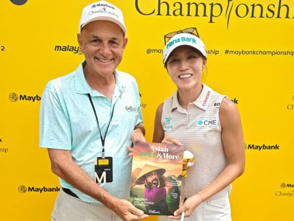 Mark Siegel and Lydia Ko holding Asian GOLF & More magazine in front of a yellow Maybank Championship backdrop.