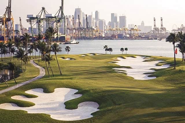 The Serapong Course at Sentosa Golf Club in Singapore, featuring sweeping fairways, white sand bunkers and a city skyline.